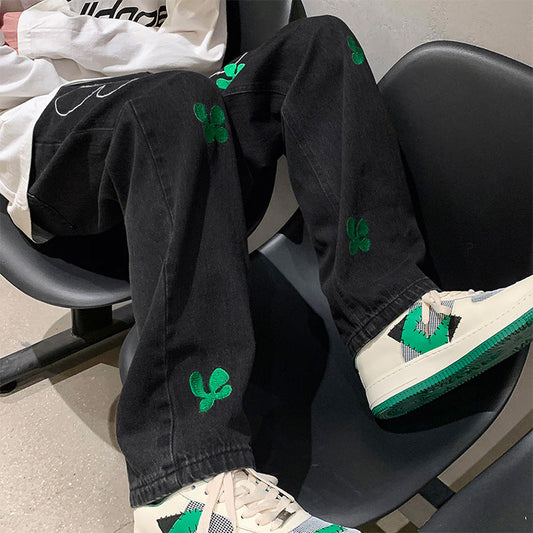 calça jeans larga masculina com trevos de plantas estampado