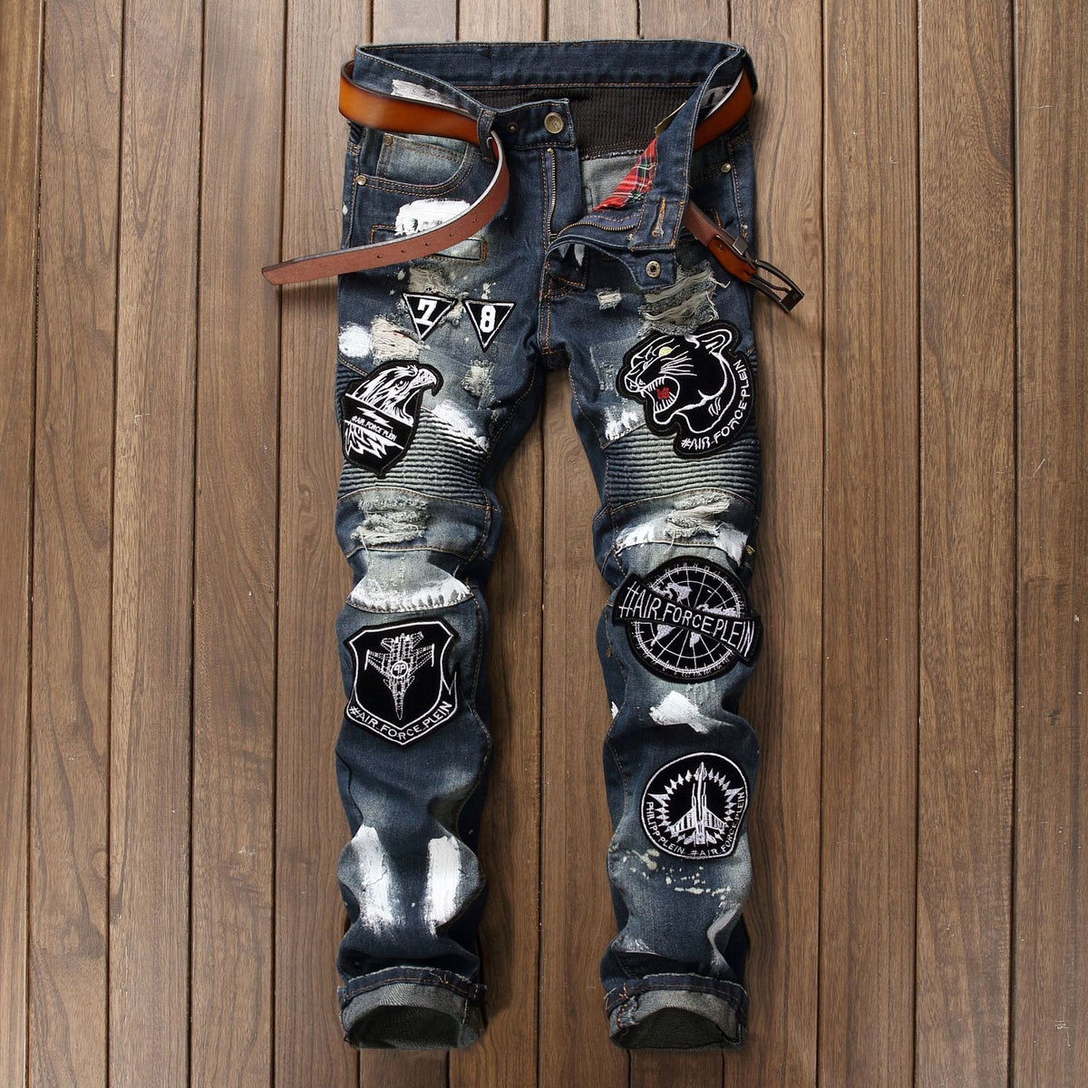 calça jeans escura estilo punk com remendas, desenhos e rasgos