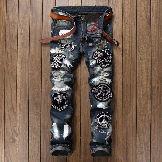 calça jeans escura estilo punk com remendas, desenhos e rasgos